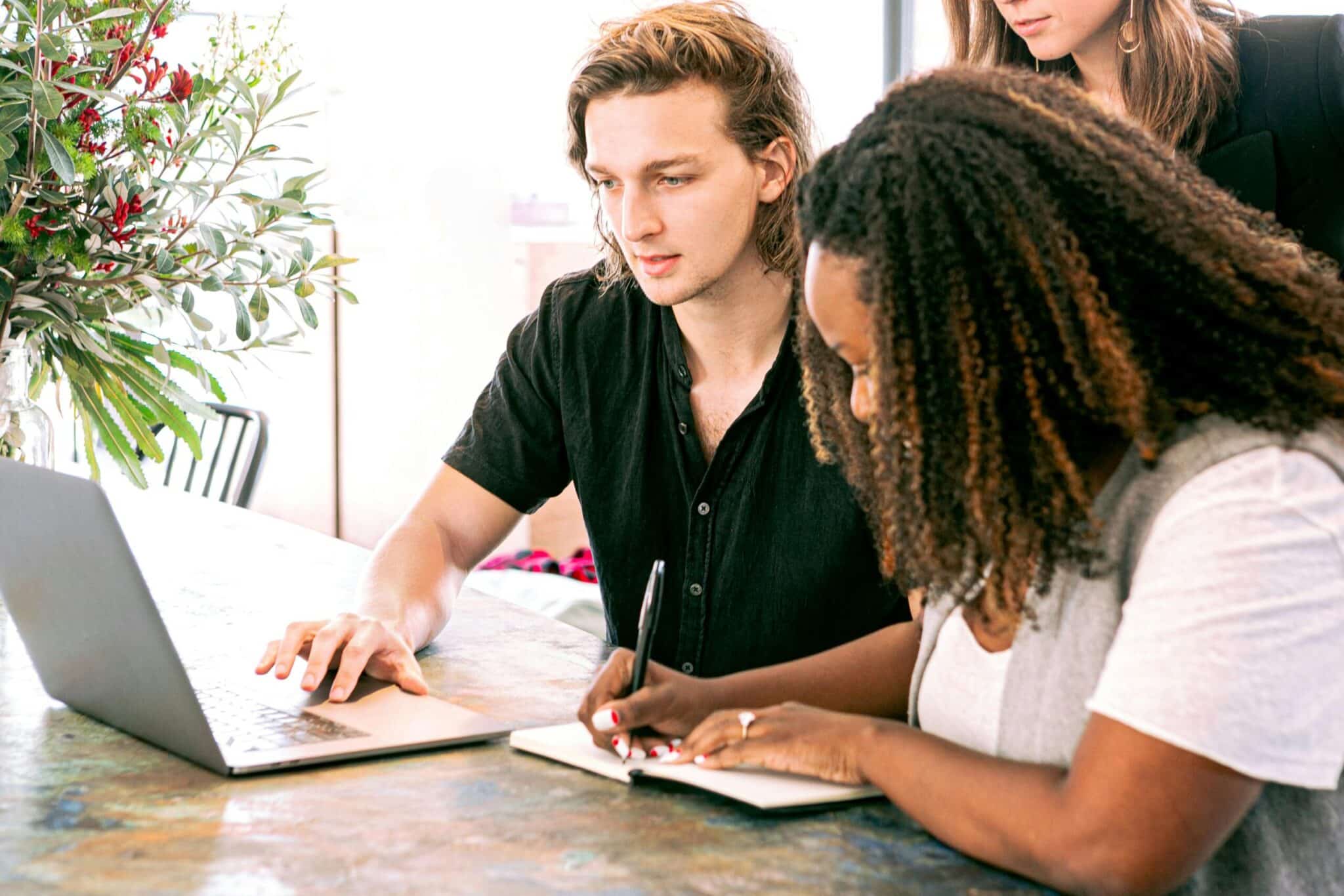 man and woman working in front of laptop